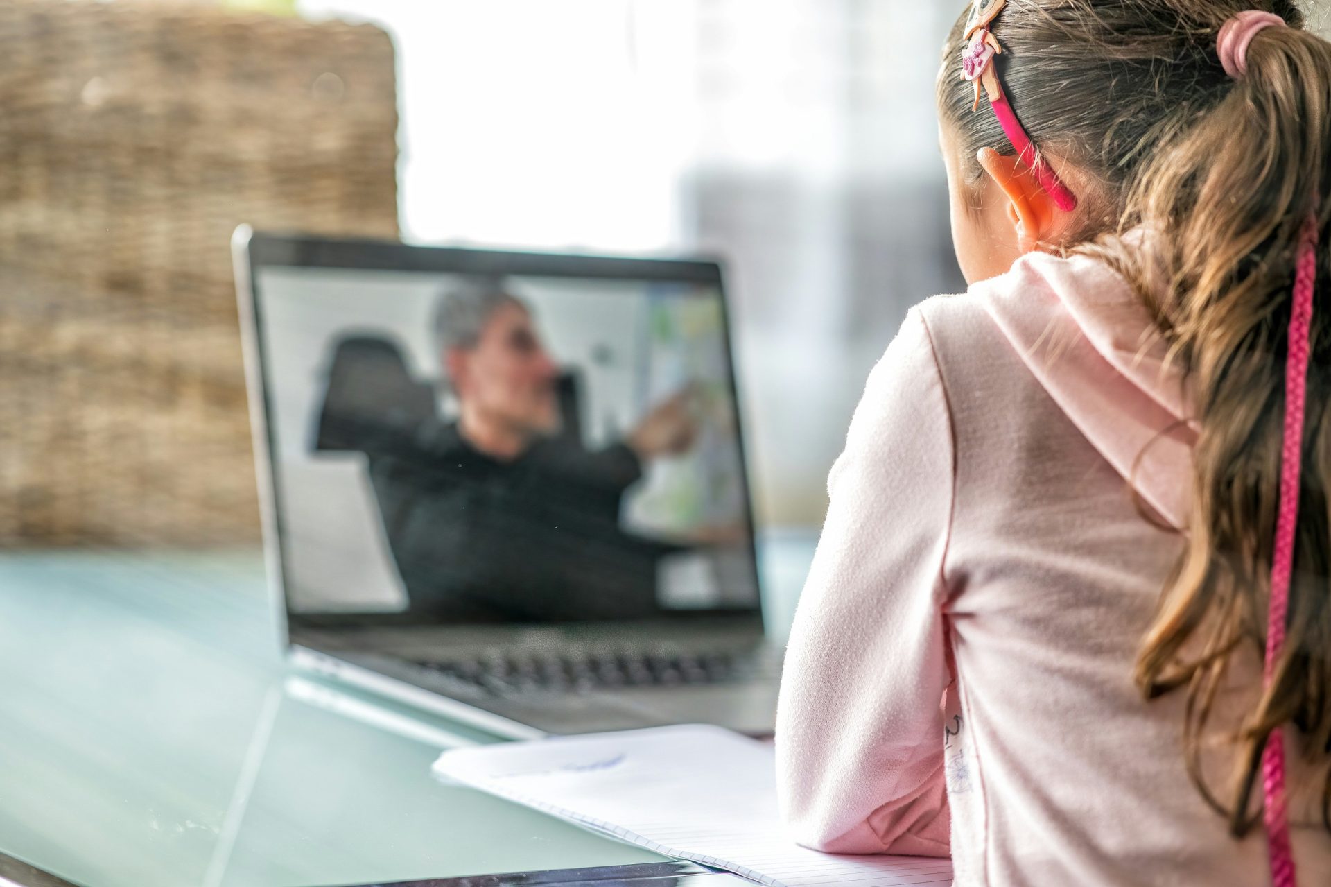 Frau in rosa Langarmshirt sitzt vor einem MacBook Pro
