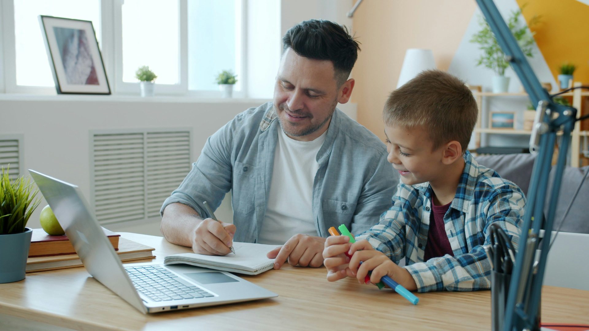 Vater und Sohn arbeiten gemeinsam an einem Schreibtisch