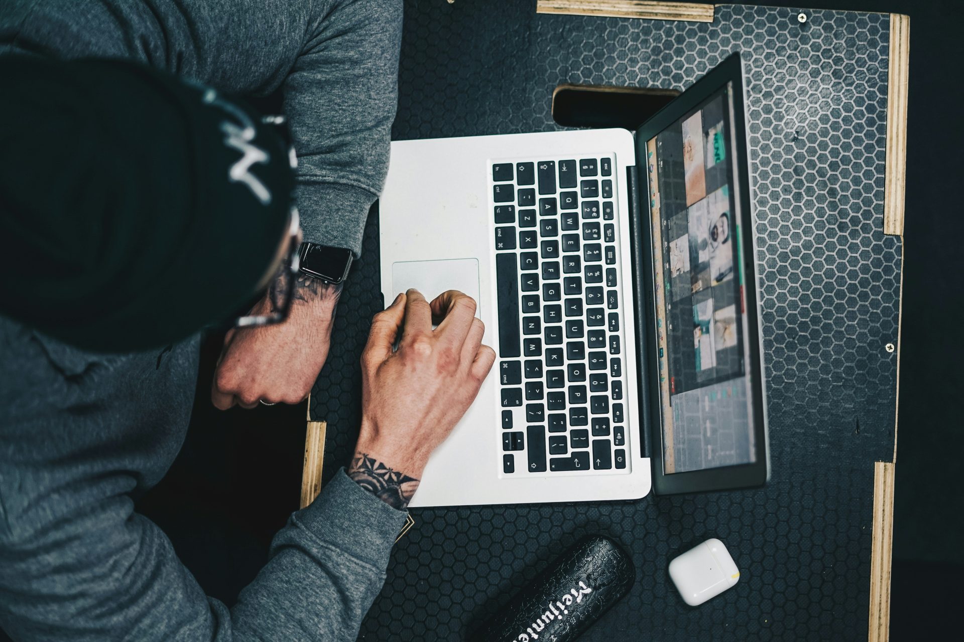 Ein Mann sitzt an einem Schreibtisch und benutzt einen Laptop.